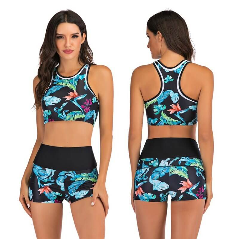 Woman wearing a colorful two-piece swimsuit with a floral pattern, featuring a cropped tank top and shorts, perfect for beach sports.